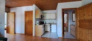 eine Küche mit weißen Geräten und Holzdecken in der Unterkunft Osserapartment Green in Lohberg