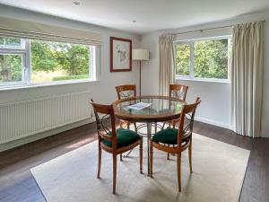 une salle à manger avec une table et des chaises en verre dans l'établissement Shepherds Loft, à Shermanbury