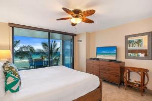 a bedroom with a bed and a large window at Mahana 307 · MA 307 OceanFront Condo w Pool AC in Kahana +44 photos