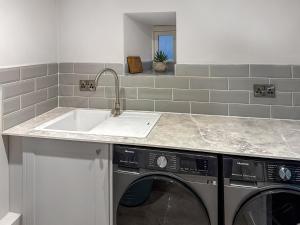 a kitchen with a sink and a washing machine at Stone's Throw in Richmond