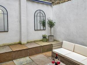 a patio with a white bench and two windows at Stone's Throw in Richmond
