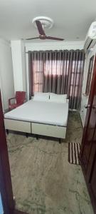 1 dormitorio con cama blanca frente a una ventana en Sri Raghavendra Inn, en Kākināda