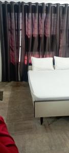 duas camas em frente a uma janela com cortinas em Sri Raghavendra Inn em Kākināda