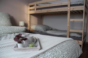 NeudorfFachwerkwinkel Erzgebirge的一张床，上面放着一个托盘，托盘里有一朵花；还有两张双层床。