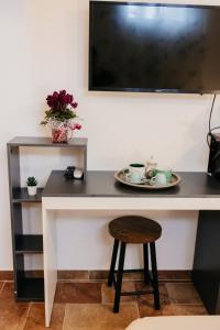 een tafel met een bord, een kruk en een tv bij Tra gli ulivi in San Cesareo