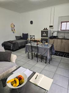 a living room with a table with a bowl of fruit at Lalapanzi - Nxabba in Olifantshoek