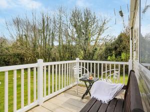 ein Holzbalkon mit einem Tisch und Stühlen darauf in der Unterkunft The Villa At Youlditch Farm in Okehampton
