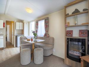 ein Wohnzimmer mit einem Tisch und einem Stuhl sowie eine Küche in der Unterkunft The Villa At Youlditch Farm in Okehampton