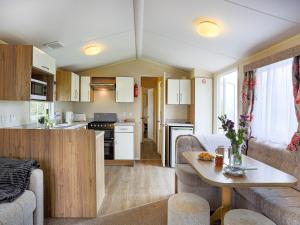 eine Küche und ein Wohnzimmer mit einer Couch und einem Tisch in der Unterkunft The Villa At Youlditch Farm in Okehampton