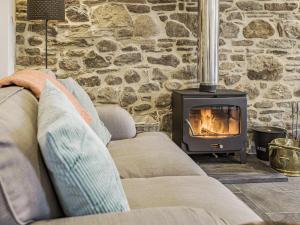 a living room with a couch and a fireplace at The Stables - Cottage in Bryngwyn