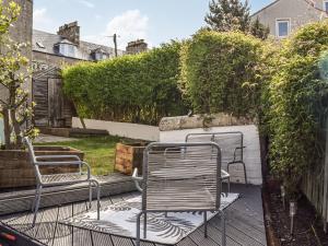 two chairs sitting on a deck in a garden at Maisie Cottage in Saint Monance