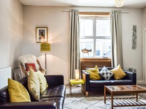 a living room with two couches and a window at Maisie Cottage in Saint Monance +10 photos