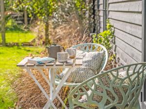 a table with books and mugs on it on a patio at The Cowshed - Uk50803 in Cratfield
