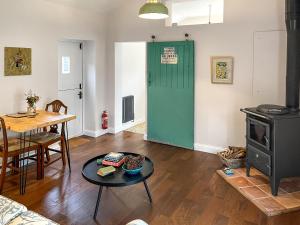 a living room with a table and a green door at The Cowshed - Uk50803 in Cratfield +4 photos