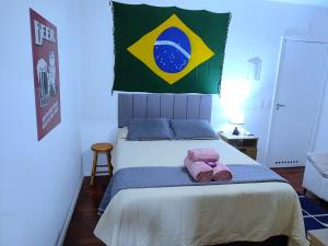 a bedroom with a bed with a flag on the wall at Jackie's Place in Petrópolis +6 photos