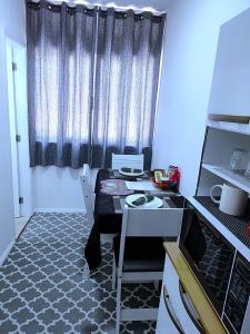 a small kitchen with a table and a window at Jackie's Place in Petrópolis