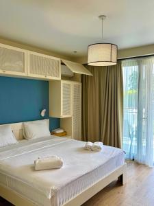 une chambre avec un grand lit avec un mur bleu dans l'établissement Terrace Kaprovan, à Shekvetili