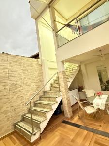 a staircase in a house with a table and chairs at Casa completa e climatizada em Ilhéus in Ilhéus