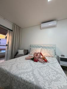 a stuffed animal laying on top of a bed at Casa completa e climatizada em Ilhéus in Ilhéus