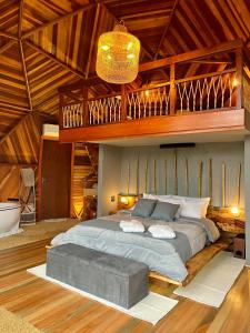 ein Schlafzimmer mit einem großen Bett und einer Holzdecke in der Unterkunft Domo Malacara View in Praia Grande