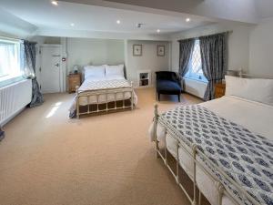 a bedroom with two beds and a chair at The Merchants Penthouse - Uk50408 in Canterbury