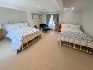 a bedroom with two beds and a chair at The Merchants Penthouse - Uk50408 in Canterbury