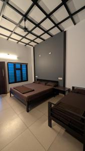 a large room with two beds and a window at Meghamalhar in Mānantoddy