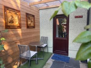 un patio con tavolo e sedie accanto a una porta di The Bluebird Porthmadog Retreat a Porthmadog