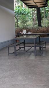 a picnic table and a bench in a building at Meghamalhar in Mānantoddy