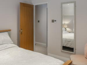 een slaapkamer met een bed en een spiegel bij The Cottage - Uk50652 in Stithians