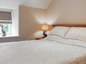 een slaapkamer met een wit bed en een raam bij The Cottage - Uk50652 in Stithians
