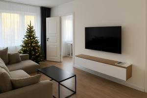 a living room with a television and a christmas tree at Moncerat in Šiauliai
