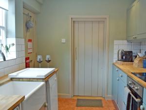 a kitchen with a white door and a counter top at Owl Cottage in Fordwich +5 photos