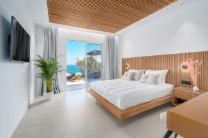 Elit Villa Psarou في بسارو: غرفة نوم بسرير كبير ونافذة كبيرة +79 صورة