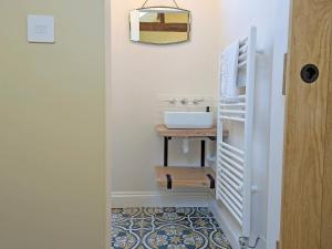 a bathroom with a sink and a vanity with a mirror at The Stables - Uk50804 in Cratfield