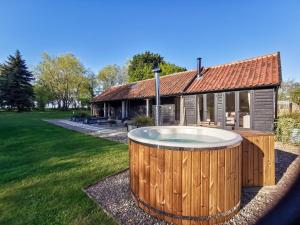 a large hot tub in front of a house at The Stables - Uk50804 in Cratfield +10 photos