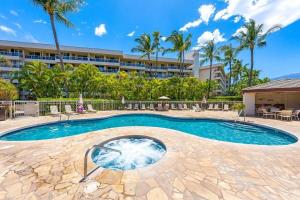 a swimming pool in front of a building at Maui Banyan P301 · MB P301 Remodeled 2BD Condo Across Beach Pool in Wailea