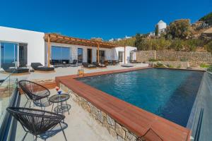 Elit Villa Psarou في بسارو: منزل به مسبح وسطح خشبي