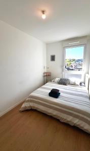 ein weißes Schlafzimmer mit einem großen Bett und einem Fenster in der Unterkunft Chic Parisien in Villemomble + 21 Fotos