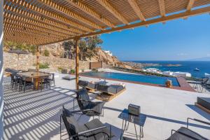Elit Villa Psarou في بسارو: فناء مع طاولة وكراسي ومسبح