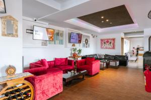 Una sala de estar con sofás rojos y una mesa. en Neptune Hotel Apartments Paphos, en Bahía de Coral