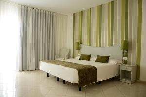um quarto com uma cama grande e uma janela grande em Ouril Pontao Hotel em Santa Maria