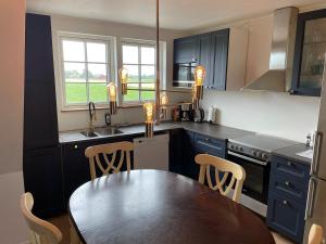 a kitchen with a wooden table and a dining room at Guest apartment on horse farm in Höganäs