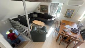 a woman in a living room with a couch and a table at Guest apartment on horse farm in Höganäs