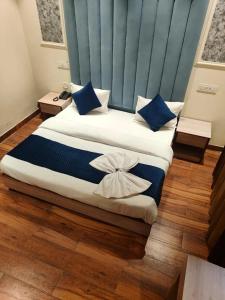 钱德加尔Hotel The SOHO的一间卧室，有两张床，配有蓝色和白色的枕头