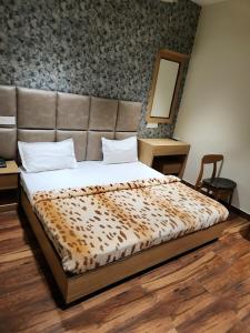 钱德加尔Hotel The SOHO的一间卧室配有一张带皮革床头板的大床
