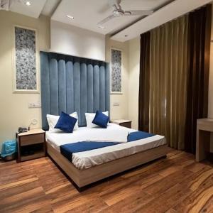 钱德加尔Hotel The SOHO的卧室里有一张大床，配有蓝色枕头