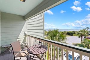 a balcony with a table and chairs and the ocean at SC206A: 206A Sea Cabin in Isle of Palms
