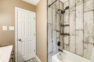 ein Badezimmer mit einer weißen Badewanne und einer Holzwand in der Unterkunft 2 Mi to Boardwalk! Bright Bethany Beach Home in Ocean View + 19 Fotos