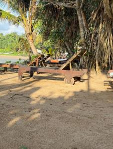 a picnic table on a beach next to a tree at New Star Villa in Bentota +14 photos